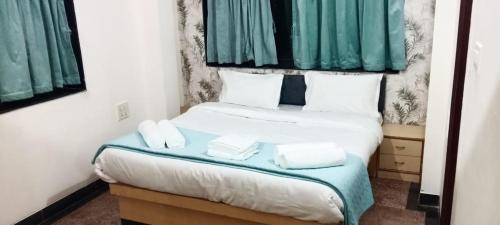 SipraにあるHillview Residencyの小さなベッドルーム(緑のカーテン付きのベッド1台付)