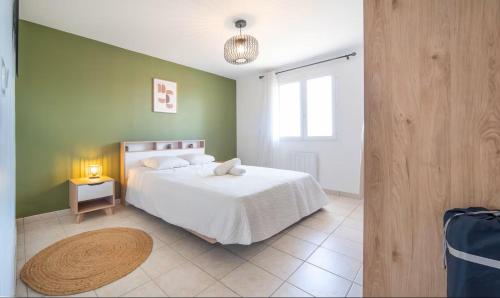 a bedroom with a white bed and a green wall at L'évasion viticole Clim- cour fermée & parking privé au pied de la roche de Solutré in Solutré-Pouilly