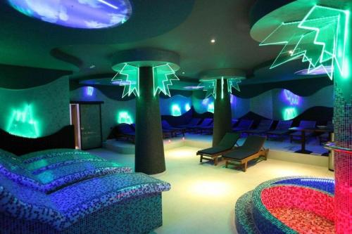 a room with purple and green lighting and furniture at Magic Apartman Kop - Kraljevi Cardaci in Kopaonik