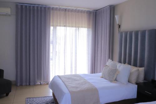 a bedroom with a bed and a large window at Oasis Hotel in Mokopane