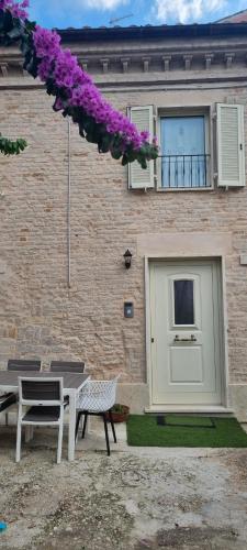 a patio with a table and chairs in front of a building at La Casa di Vina in Fermo