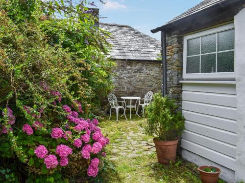 a garden with a table and chairs and flowers at Skyber - Uk50374 in Camelford