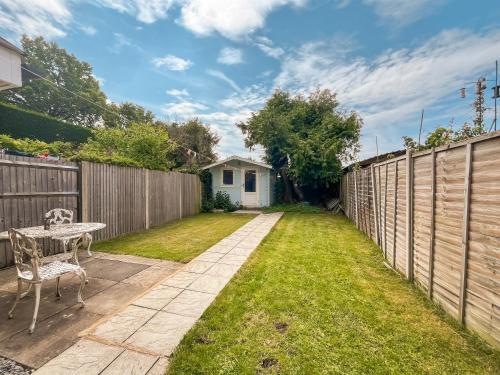 a backyard with a table and a fence at Nursery Road Cottage in East Peckham