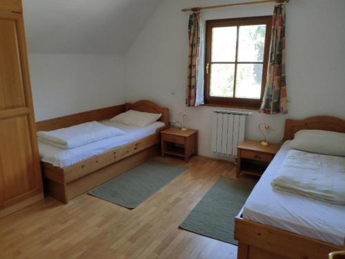 a bedroom with two beds and a window at Antela - large apartment 142m2 for 12 persons in Pohorje