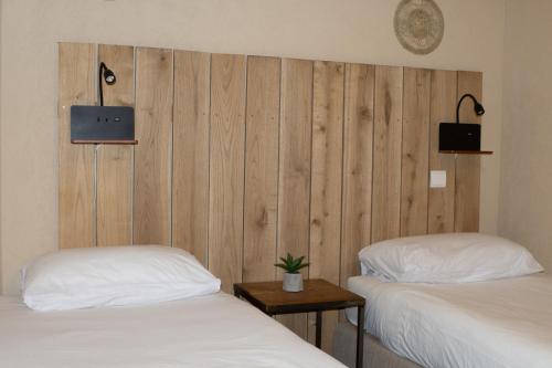 a room with two beds and a wooden wall at Domaine de Brise Bois - Chambres & Gîtes in Rouzède