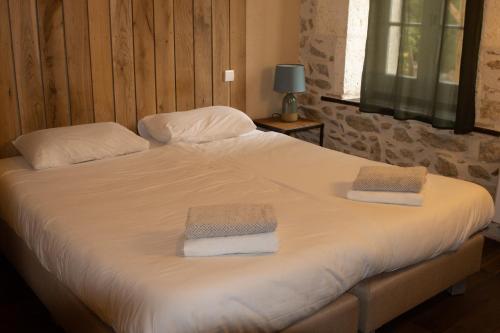 a bedroom with a bed with two towels on it at Domaine de Brise Bois - Chambres & Gîtes in Rouzède