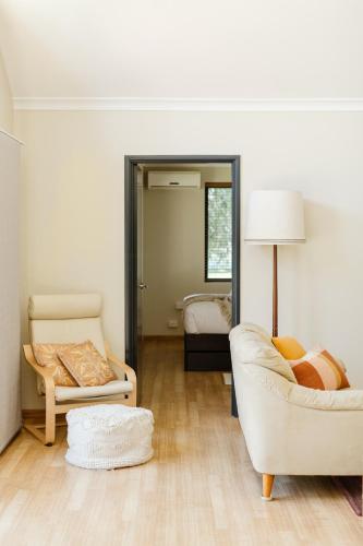 a living room with two chairs and a mirror at Purple Shore Spacious Family Stay Near Busselton Jetty in Busselton