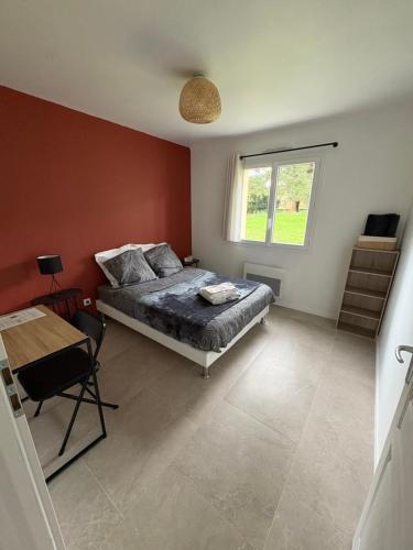 a bedroom with a bed and a table and a window at Gîte 3 Ptits Chats in Saint-Aubin