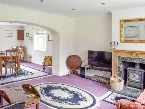 a living room with a fireplace and a tv at Glebe Farm Cottage in Hornby