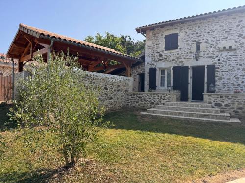 a stone house with a stone wall at Domaine de Brise Bois - Chambres & Gîtes in Rouzède