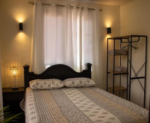 a bedroom with a bed with two pillows and a window at Comfortable apartment in Los Naranjos in Bajo Boquete