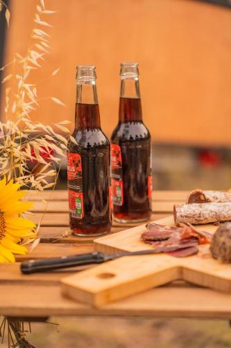 two bottles of beer sitting on top of a table at Homnest - Observatoire des Préalpes & Cheval in Puy-Saint-Martin