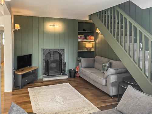 a living room with a couch and a fireplace at The Old School in Kettlewell