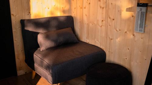 a brown chair with a pillow on top of it at Tiny-House à 1h20 de Lyon - Salle de bain italienne - Lit Grand confort in Bruailles