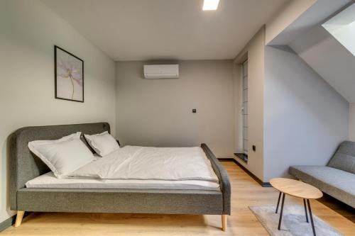 a bedroom with a bed and a couch and a chair at La Shara Building in Sofia