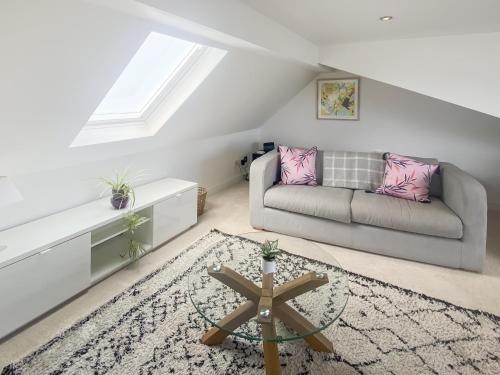 een woonkamer met een bank en een tafel bij The Loft - Uk50517 in Falmouth