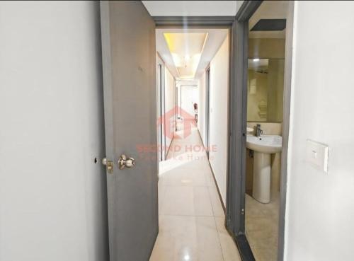 a hallway of a bathroom with a sink and a mirror at Newly Apt taman Rasuna 3BR tower 16 07 E in Jakarta