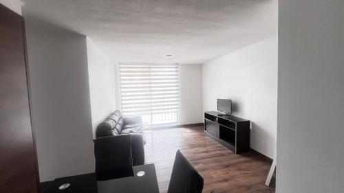 a living room with a couch and a television at Acogedor departamento en La Serena in La Serena