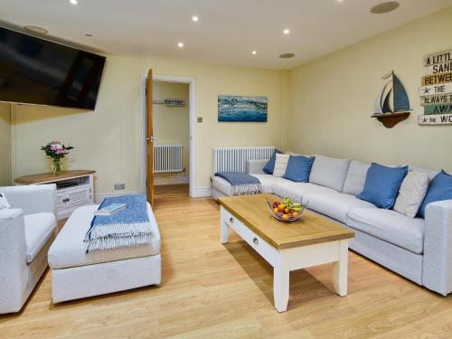 a living room with a couch and a table at Black Rock Hideaway in Porthmadog