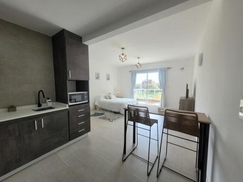 a kitchen with a counter and chairs in a room at Studio Ezeiza Aeropuerto 204 in Ezeiza