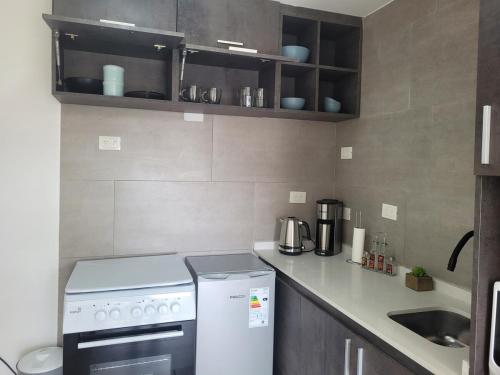 a small kitchen with a stove and a sink at Studio Ezeiza Aeropuerto 204 in Ezeiza