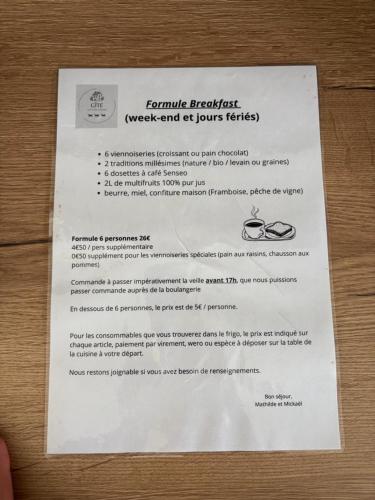 a piece of paper sitting on a table with glasses at Gîte 3 Ptits Chats in Saint-Aubin