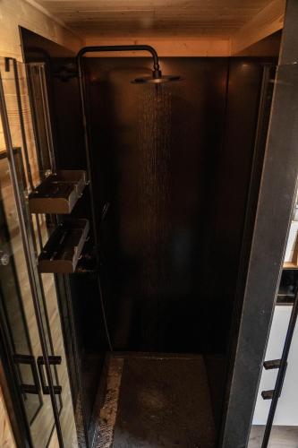 a shower in a room with a black wall at Homnest - L'Indiana Ranch - 20 min de Vichy in Espinasse-Vozelle