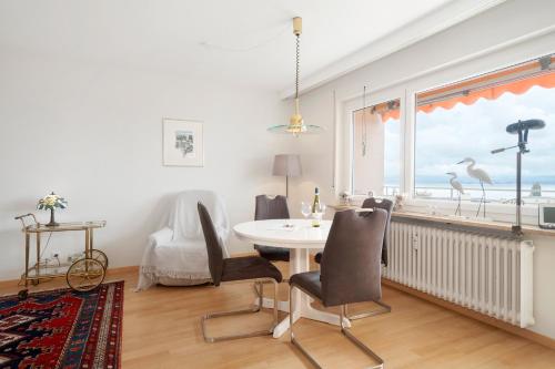 a dining room with a table and chairs and a window at Bodenseewohnung Bär in Immenstaad am Bodensee