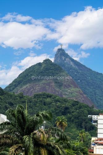 a mountain with a cross on top of it at Apê com piscina e academia: Metrô 350m in Rio de Janeiro