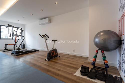 a gym with cardio equipment in a white room at Apê com piscina e academia: Metrô 350m in Rio de Janeiro