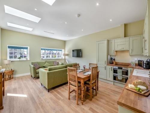 a kitchen and living room with a couch and a table at Bracken At Holly House - Uk44469 in Newton