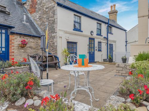a patio with a table and chairs in front of a house at The Winch in Swanage