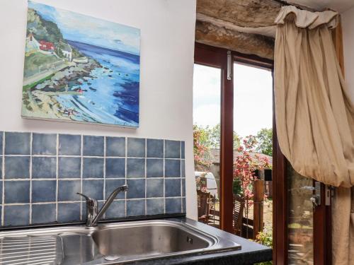 a kitchen sink with a view of a beach at Wildflower Cottage in Lealholm