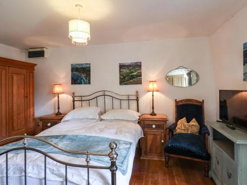 a bedroom with a bed and a mirror and a tv at Wildflower Cottage in Lealholm