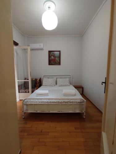 a bedroom with a bed in a white room at Hellen Guest House in Mesochórion