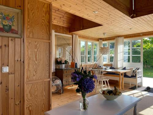 ein Wohnzimmer mit einem Tisch und einer Blumenvase in der Unterkunft Cottage With Views Over Nature Reserve In Arild in Arild