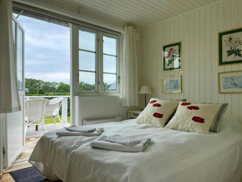 ein weißes Bett in einem Zimmer mit Fenster in der Unterkunft Cottage With Views Over Nature Reserve In Arild in Arild