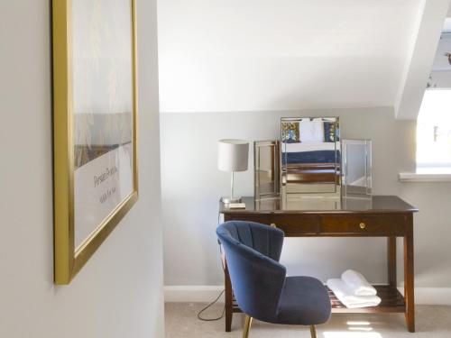 a desk with a blue chair in a room at Littlecroft in Alnmouth