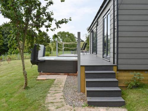 a house with a deck with a hot tub at Ponsford Ponds Jacks Shepherd Hut - Bcponhut in Cullompton