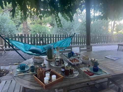 a table with food and a hammock on a deck at To a Book House in Corsica - chambres d'hôtes in Oletta