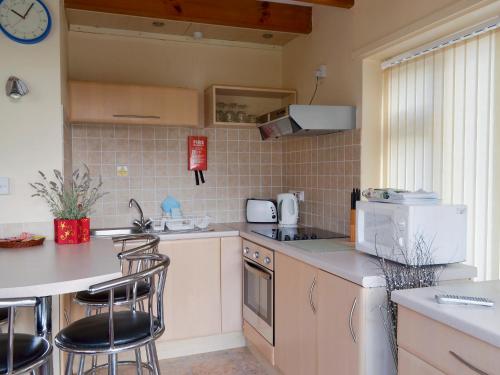 a kitchen with a counter and some stools in it at Flat F1 in Dawlish Warren