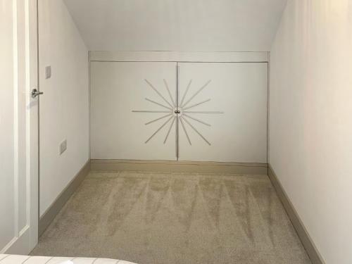 an empty room with a wall with a clock on it at The Bungalow in Rushton Spencer