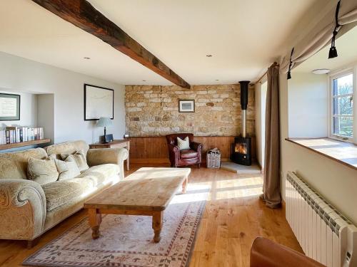 a living room with a couch and a table at Mullins Cottage in Gristhorpe