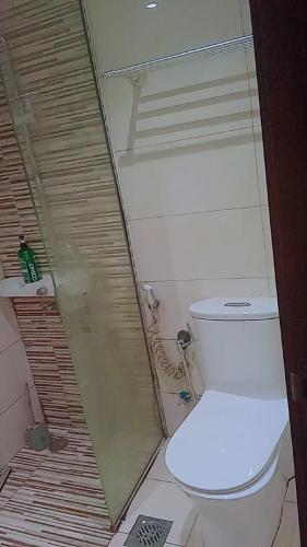 a small bathroom with a toilet and a shower at TellaHomes in Dubai