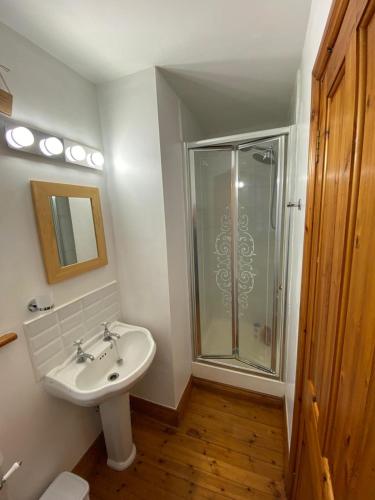 a bathroom with a sink and a glass shower at Room Stay 