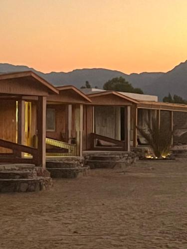 a house in the desert with a sunset in the background at Heaven Dune Camp in Nuweiba