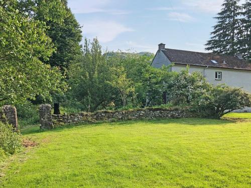 a stone wall in front of a house at Bridge Park in Killin