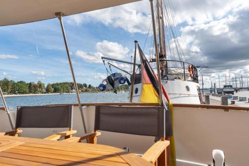 a boat with a table and chairs on the water at Klassische Motoryacht Ocean Motion in Eckernförde