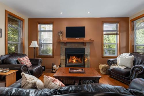 a living room with couches and a fireplace at L'Aiglon - Nature Golf and Relaxation in Mont-Tremblant in Mont-Tremblant
