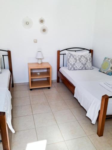 a bedroom with two beds and a night stand at My Plaka Beach Vacation Home in Plaka